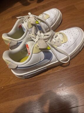 Nike White Sneakers with Blue Swoosh and Yellow Accents